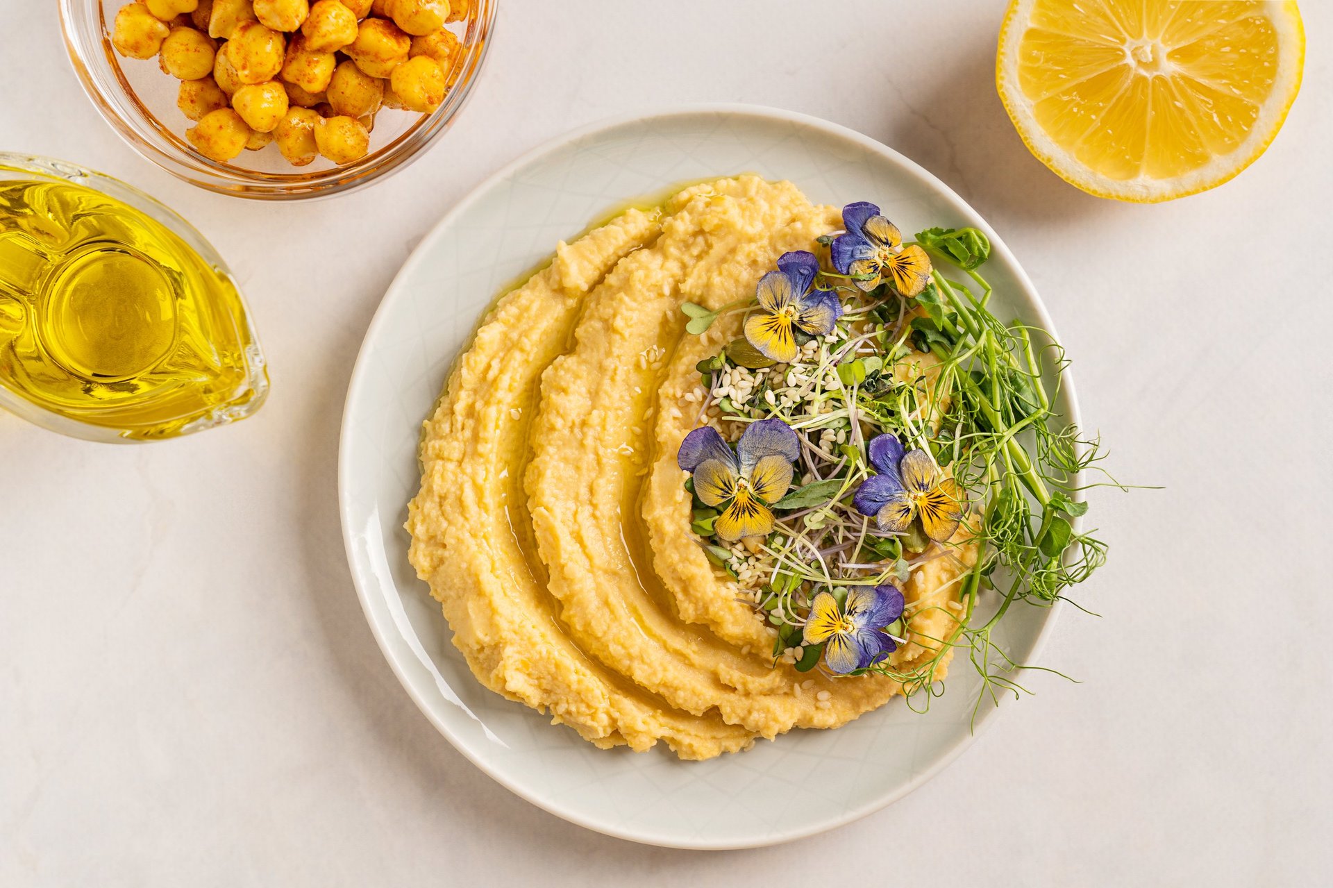 Gourmet hummus decorated with microgreens and edible flowers
