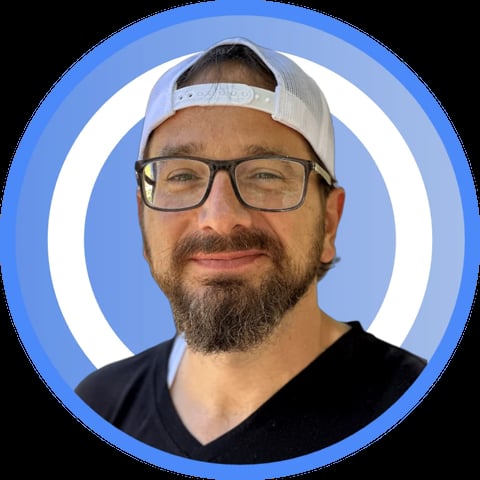 Man with beard and glasses wearing a white headband and black shirt in a circular blue profile portrait